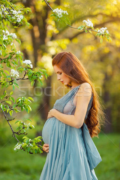Gyönyörű terhes nő virágzó kert áll fák Stock fotó © artfotodima