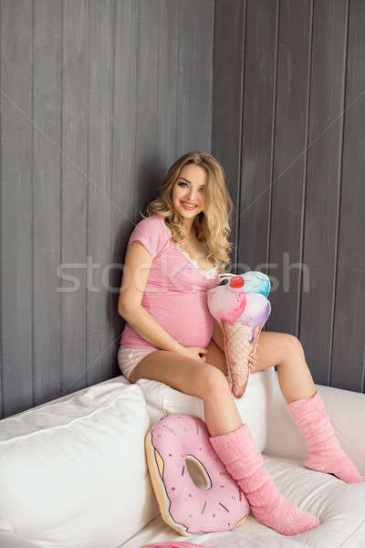 Pregnant woman with toys of ice cream posing indoors at home. Heath care and food consept. Stock photo © artfotodima