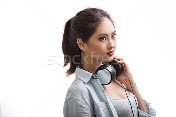 Young beautiful woman listening to music with big headphones isolated white background Stock photo © artfotodima