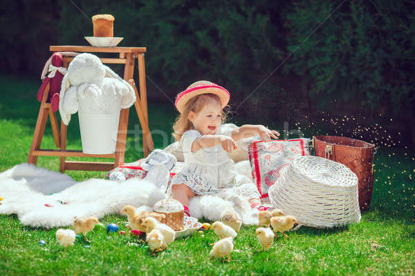 Happy child sits on a meadow around Easter decoration Stock photo © artfotodima