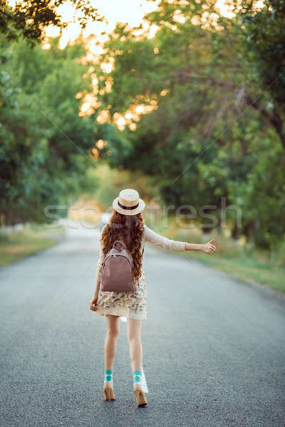 Girl with hat and backpack hitchhiking on the road Stock photo © artfotodima