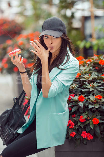 Young asian woman eating fast food outdoors Stock photo © artfotodima