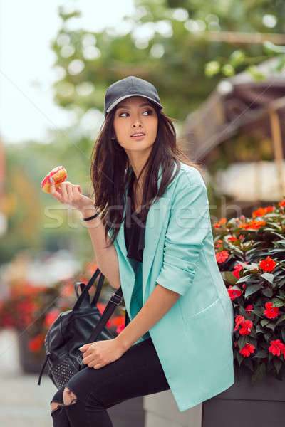 Young asian woman eating fast food outdoors Stock photo © artfotodima