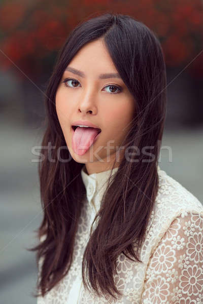 Beautiful asian woman showing tongue Stock photo © artfotodima