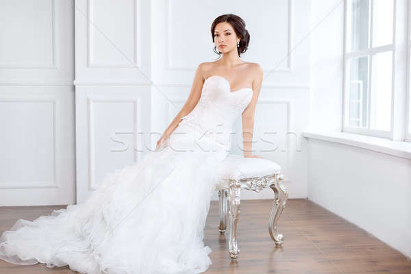 Bride in beautiful dress sitting on chair indoors Stock photo © artfotodima