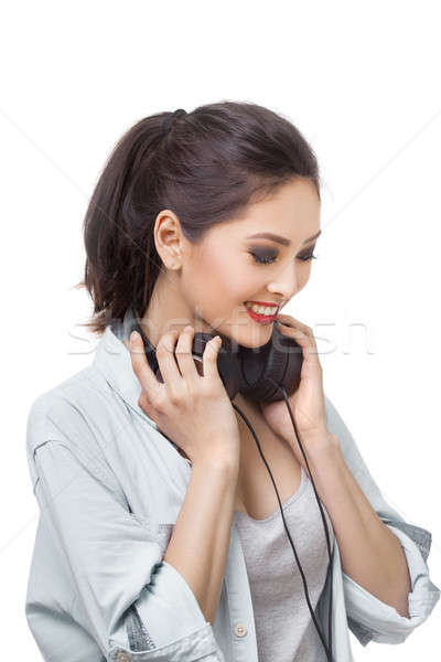 Young beautiful woman enjoy listening to music with big headphones isolated white background Stock photo © artfotodima