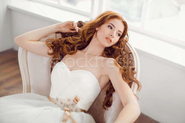 Bride in beautiful dress laying resting on sofa indoors Stock photo © artfotodima