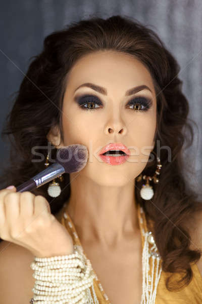 Stock photo: Female face with brush applying make-up