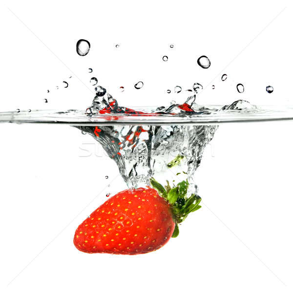 Fresh strawberry dropped into water with splash isolated on white Stock photo © artjazz