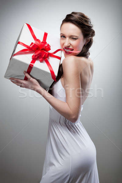 Stock photo: Young smiling woman holding gift 