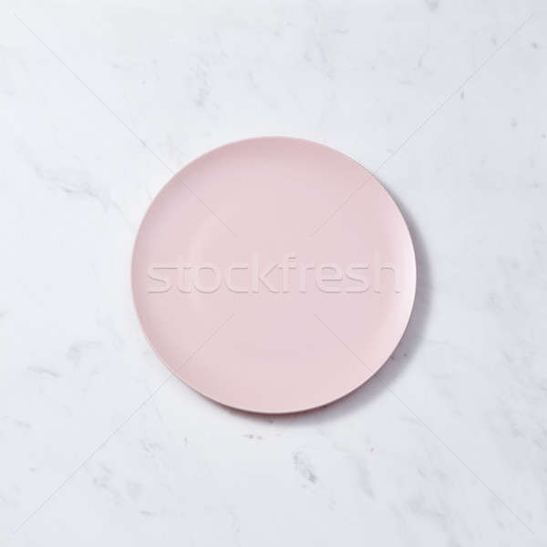 Porcelain handmade empty plate in a pastel color on a gray marble table. Flat lay Stock photo © artjazz