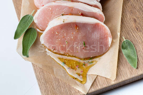 Stock photo: raw pork escalope with sause made of honey and herbs