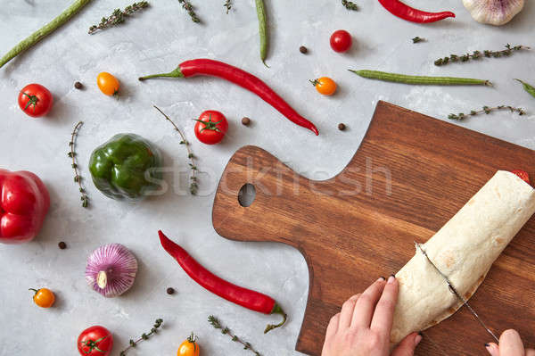 The girl cuts the finished burrito Stock photo © artjazz