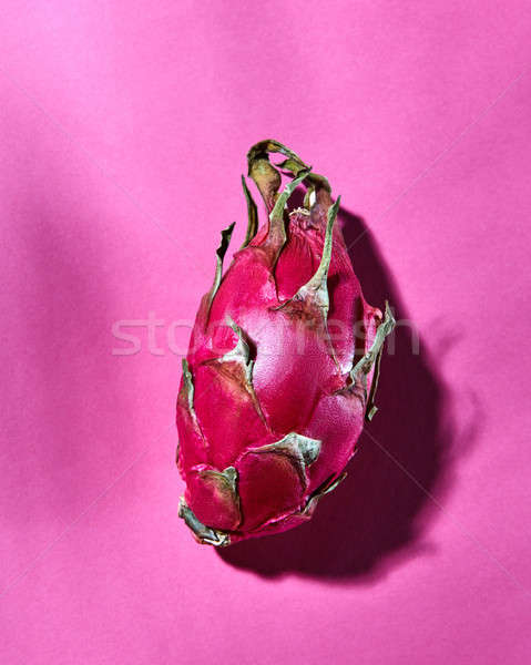 Juicy pink pitaya on a dark pink background with shadows Stock photo © artjazz
