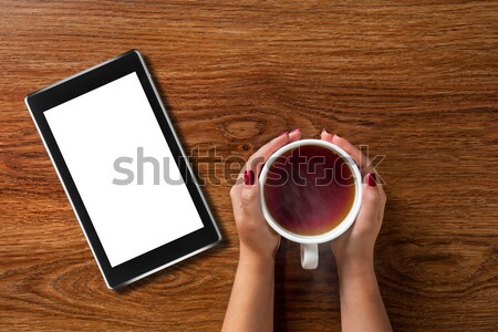 woman holding cup of tea with tablet pc on wood Stock photo © artjazz