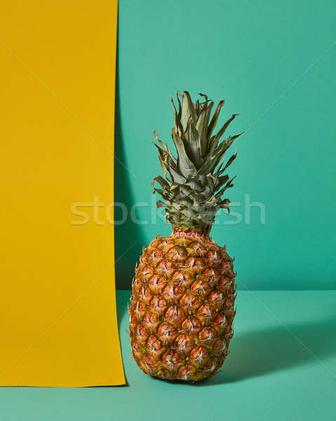 Exotic fruit of pineapple presented on a green yellow background Stock photo © artjazz