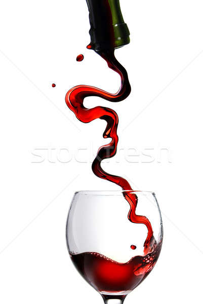 Pouring red wine in glass goblet isolated on white Stock photo © artjazz
