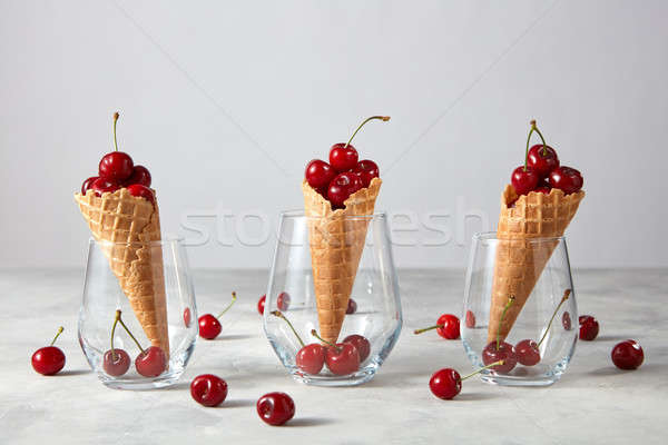 Stock photo: Freshly picked ripe cherries in a sweet wafer cones standing in 