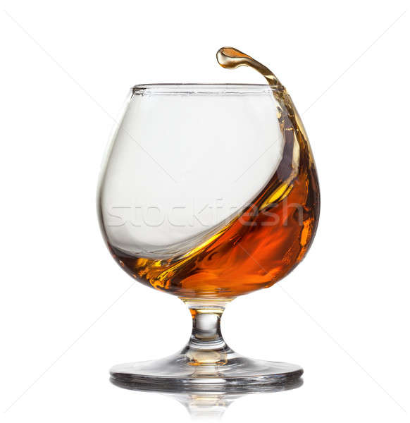 Splash of cognac in glass isolated on white background Stock photo © artjazz
