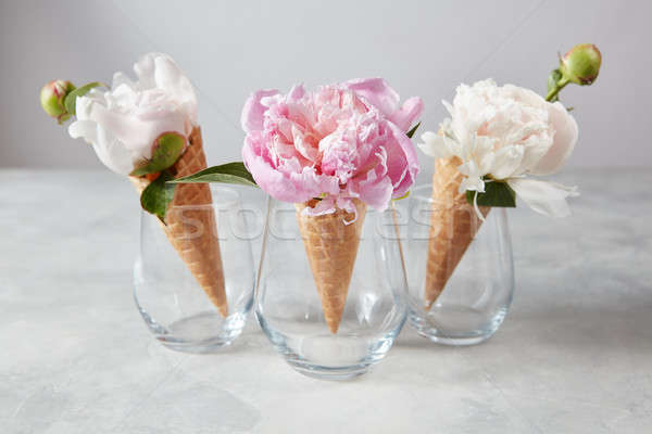 Sweet waffle cones with beautiful coloful peony flowers in glass Stock photo © artjazz