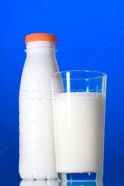 Milk in glass and bottle isolated on blue Stock photo © artjazz