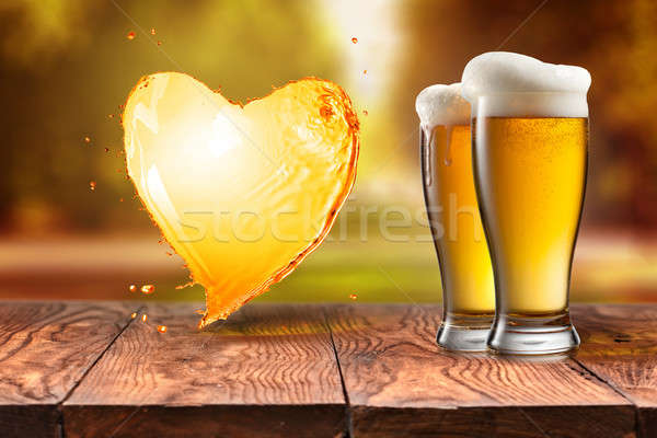 Love beer. Beer in glass with heart splash on wooden table again Stock photo © artjazz