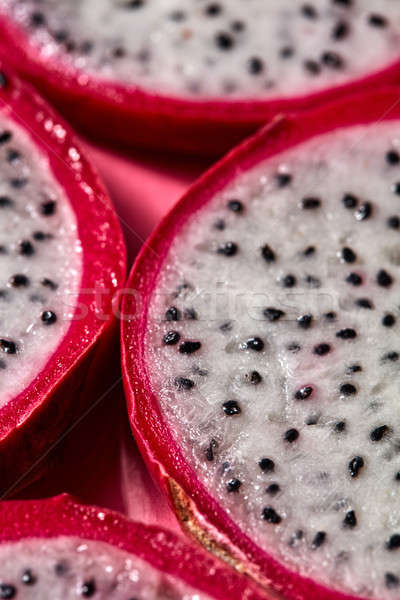 Stock photo: Close-up view of background from round slices of Dragon fruit or Pitaya on a pink background.