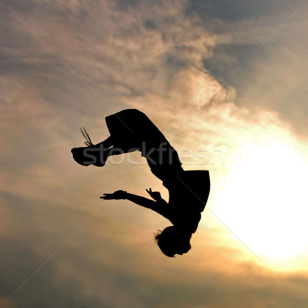 silhouette of jumping man against sky and clouds Stock photo © artjazz