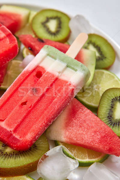 Close-up fruit frozen smoothies on a stick in the form of a piece of watermelon in a plate with ice  Stock photo © artjazz