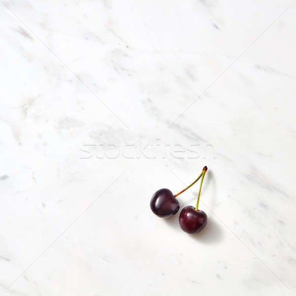 Red sweet cherries on a marble background with copy space. Stock photo © artjazz