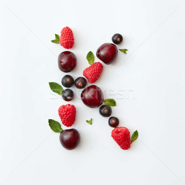 Summer pattern of letter K english alphabet from natural ripe berries - black currant, cherries, ras Stock photo © artjazz