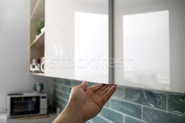 male hand open the cupboard doors in the kitchen Stock photo © artjazz