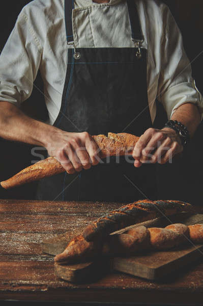 Stock photo: Male hands break the baguette