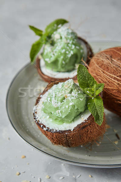 Delicious homemade mint ice cream in a coconut shell on a plate  Stock photo © artjazz