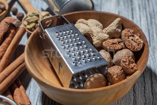 Ginger with nutmeg and grater in bowl on wood Stock photo © artjazz