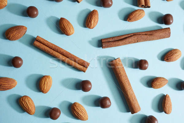 raw unpeeled almonds with a cinnamon stick and chocolate balls on a blue background Stock photo © artjazz