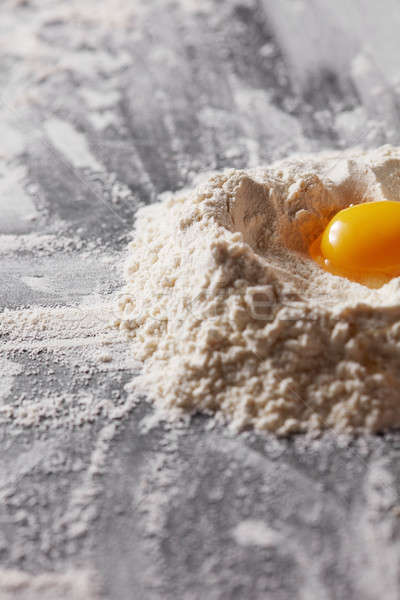 Fresh egg and flour on the kitchen table. Preparation for kneading the dough Stock photo © artjazz