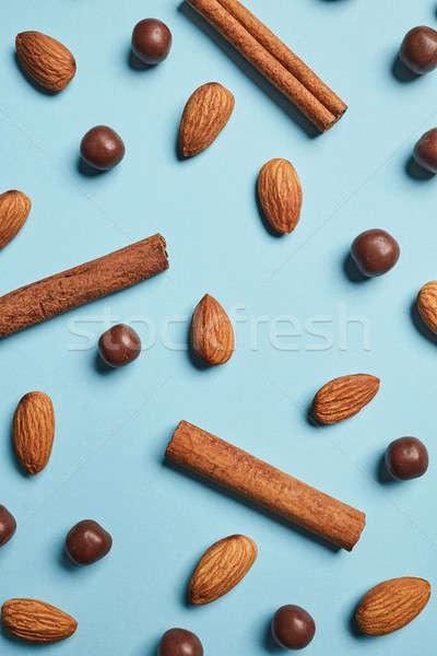 Stock photo: raw almonds, cinnamon sticks and chocolate balls on a blue background