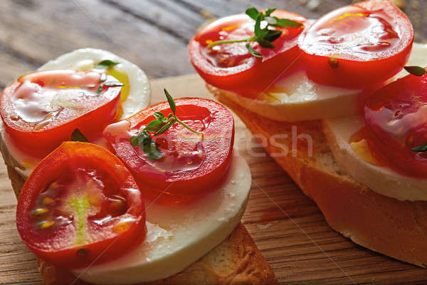 Foto d'archivio: Bruschetta · pomodorini · mozzarella · basilico · legno