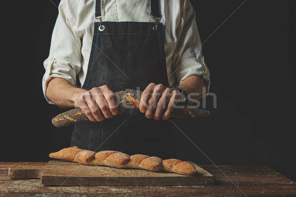 Men's hands hold divided baguette halves Stock photo © artjazz