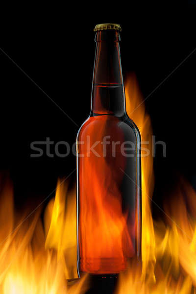 Beer bottle in fire on black Stock photo © artjazz