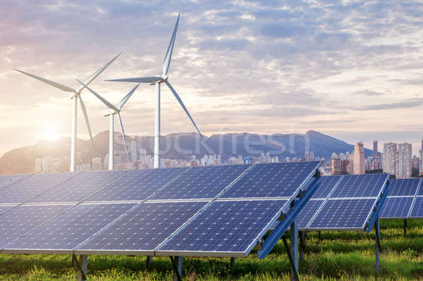 Solar panels and wind turbines with city Stock photo © artjazz