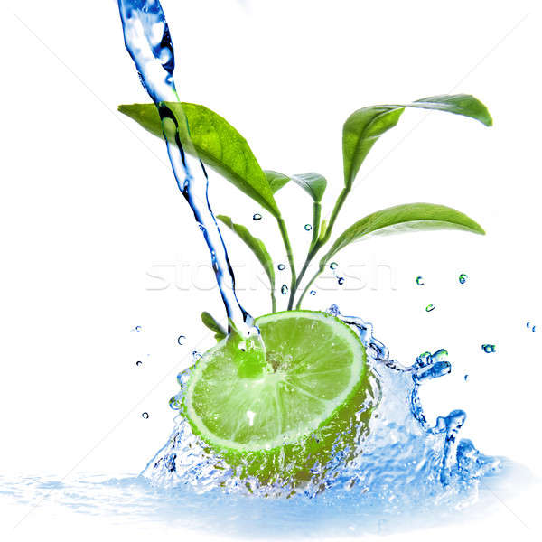 Stock photo: water drops on lime with green leaves isolated on white