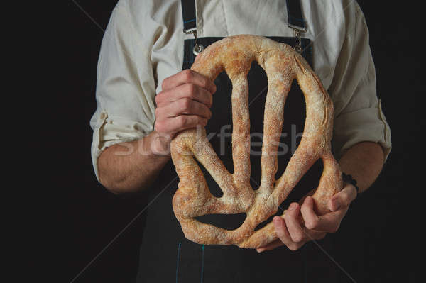 Baker's hands hold fougas bread Stock photo © artjazz