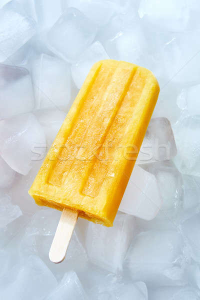 Stock photo: Orange peach ice cream lolly presented on ice cubes. Natural healthy summer dessert. Top view