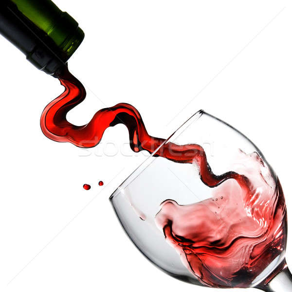 Stock photo: Pouring red wine in glass goblet isolated on white