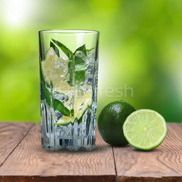 mohito cocktail on wooden table against green background Stock photo © artjazz
