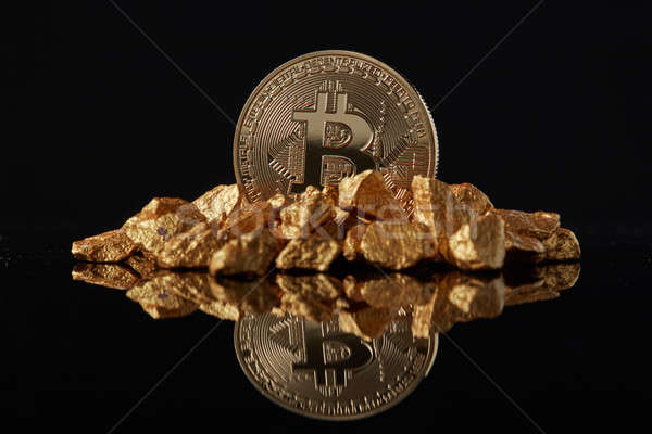 Golden Bitcoin Coin and mound of gold on a dark background. Stock photo © artjazz
