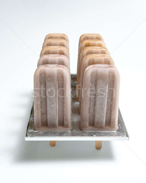 Chocolate ice cream on stick in plastic molds with shiny shadows on white background with space for  Stock photo © artjazz