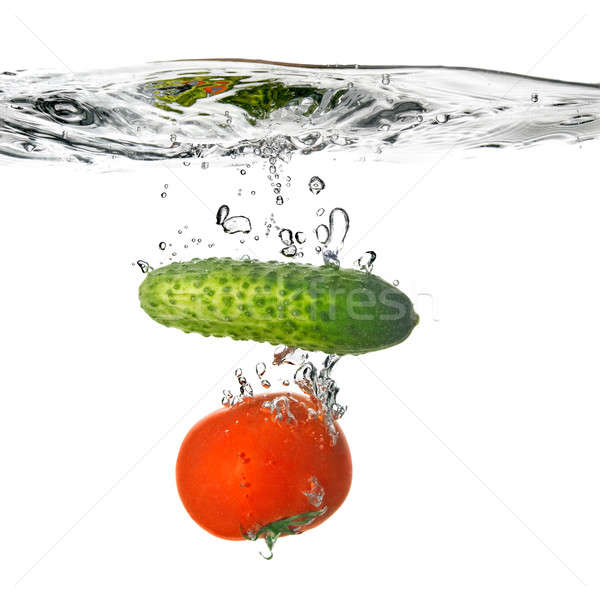 Stock photo: tomato and cucumber dropped into water isolated on white